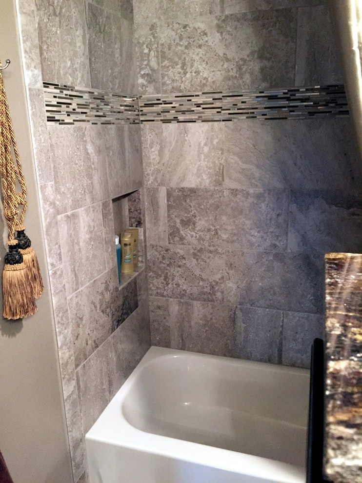 Cette photo montre une salle de bain tendance avec un combiné douche/baignoire, des carreaux de céramique, un sol en carrelage de céramique, un placard avec porte à panneau surélevé, des portes de placard noires, un plan de toilette en quartz modifié et un mur gris.