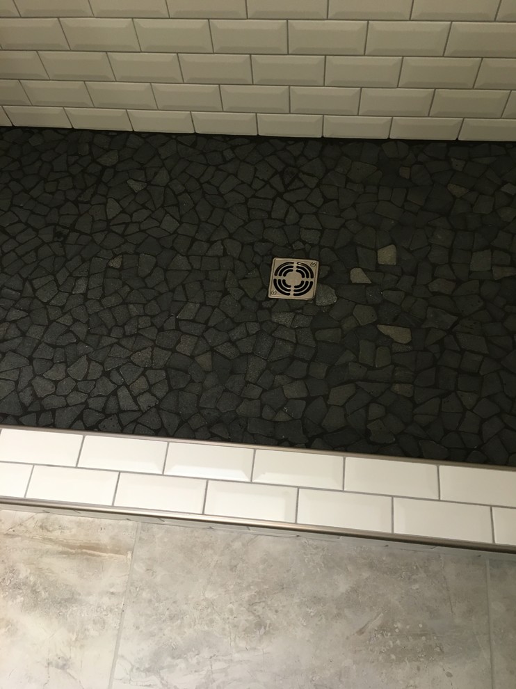 Foto di una stanza da bagno design con WC a due pezzi, piastrelle bianche, piastrelle in ceramica, pareti bianche e pavimento con piastrelle di ciottoli