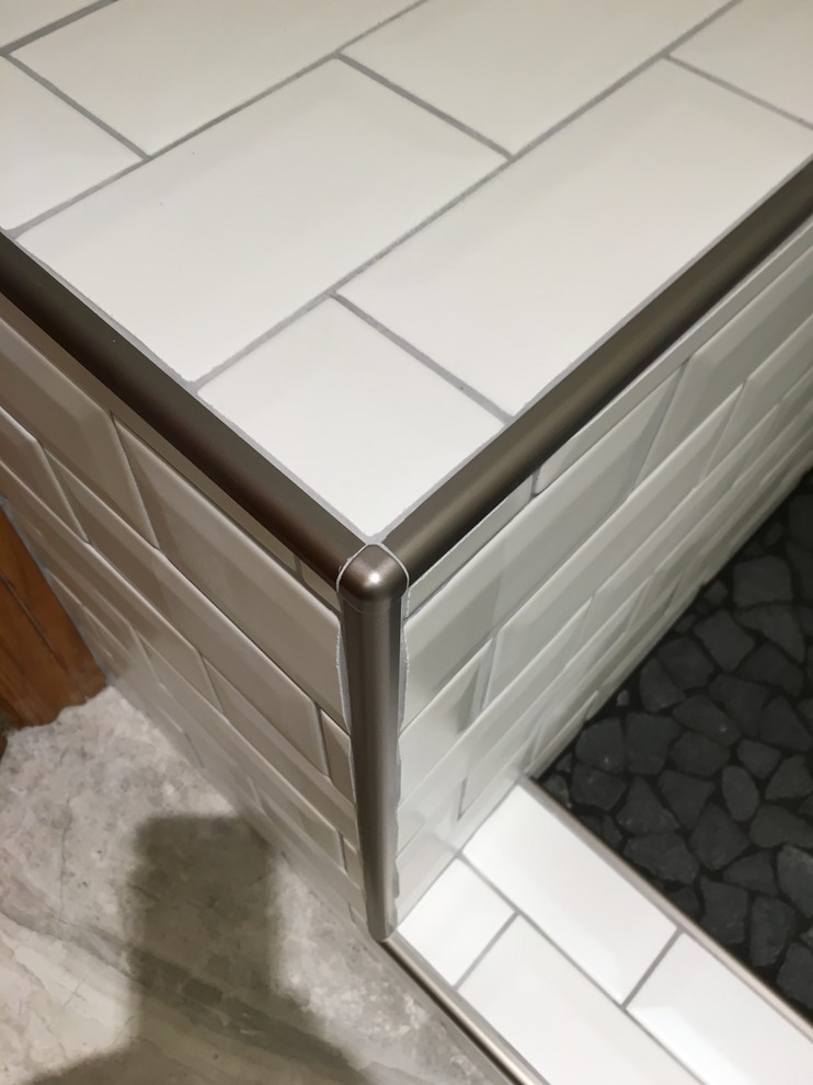 Ispirazione per una stanza da bagno minimal con WC a due pezzi, piastrelle bianche, piastrelle in ceramica, pareti grigie e pavimento con piastrelle di ciottoli