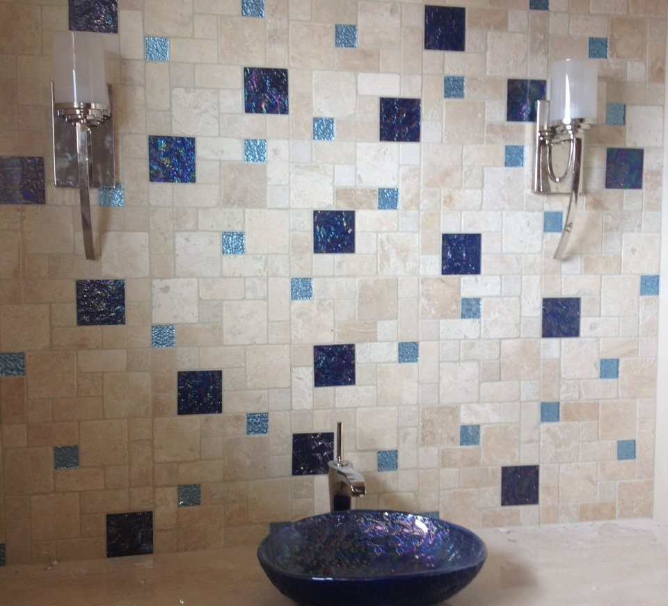 Esempio di una stanza da bagno tropicale con lavabo a bacinella, piastrelle di vetro e pareti blu