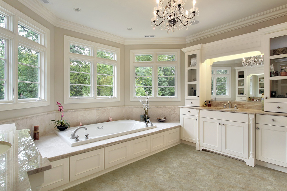На фото: большая главная ванная комната в классическом стиле с фасадами с утопленной филенкой, белыми фасадами, накладной ванной, бежевыми стенами и врезной раковиной