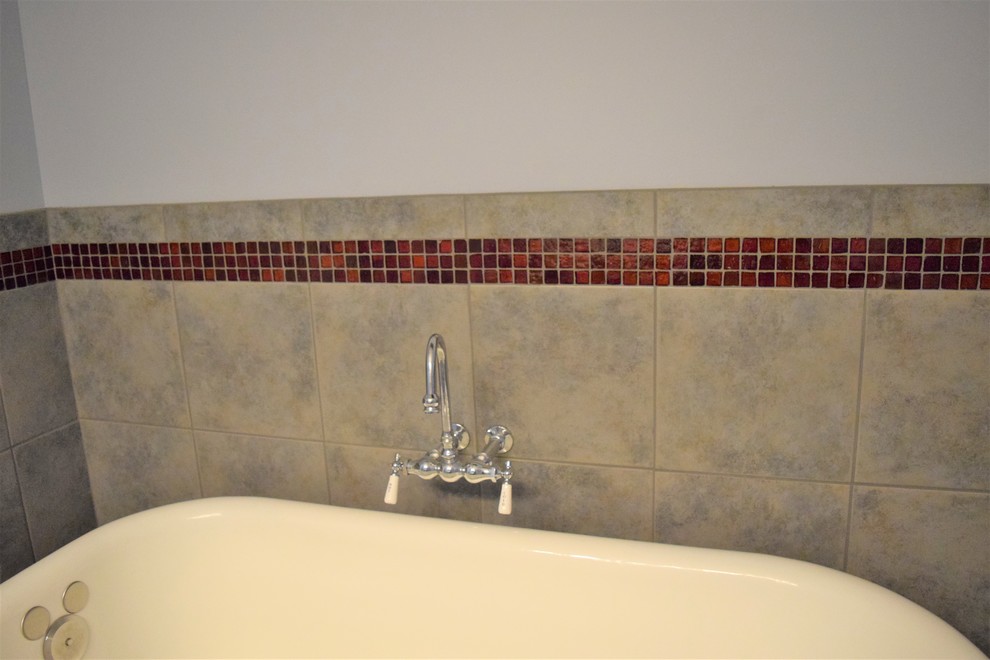Exempel på ett mellanstort klassiskt en-suite badrum, med ett badkar med tassar, brun kakel och keramikplattor