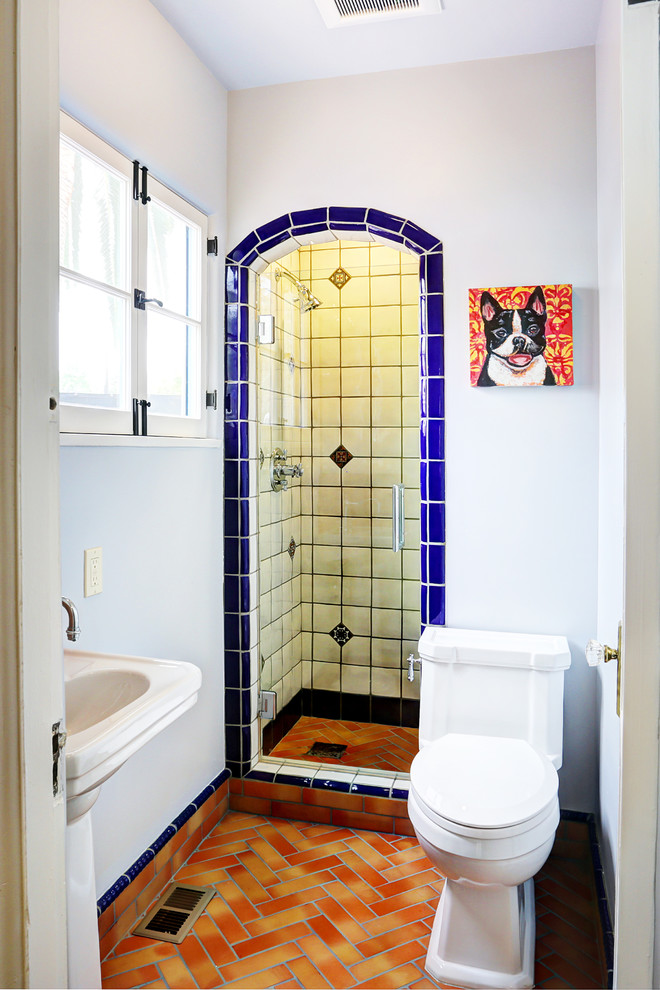 Mediterranes Duschbad mit Sockelwaschbecken, Duschnische, Wandtoilette mit Spülkasten und weißer Wandfarbe in Sonstige