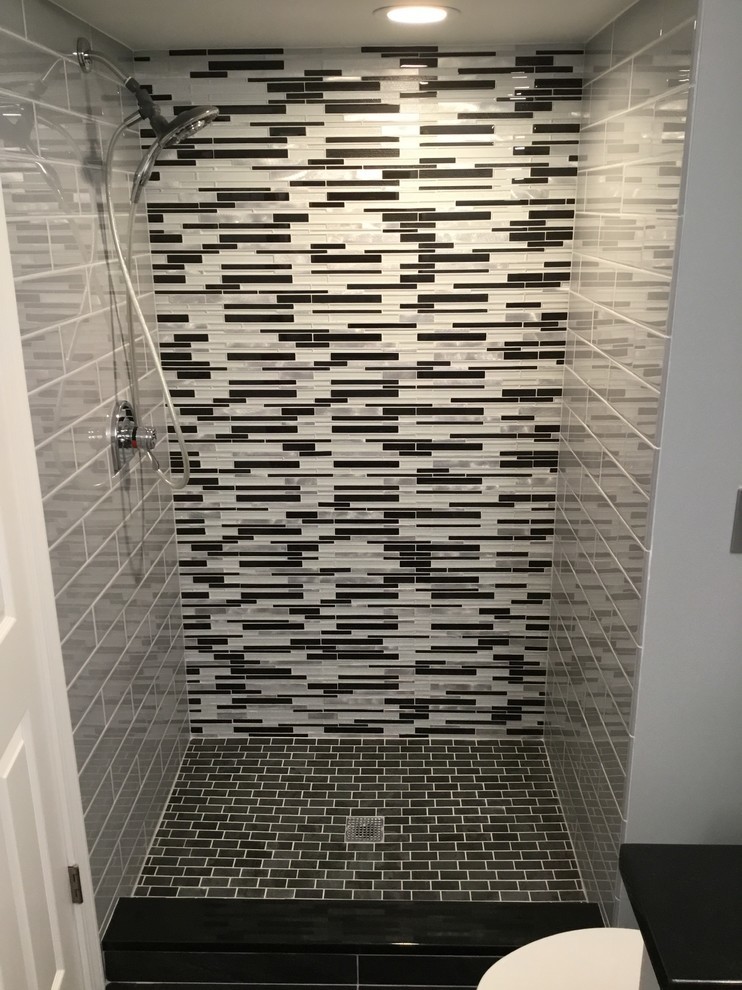 Alcove shower - small contemporary 3/4 black and white tile and glass tile porcelain tile and black floor alcove shower idea in Detroit with flat-panel cabinets, white cabinets, gray walls, an undermount sink, granite countertops, a hinged shower door and a one-piece toilet