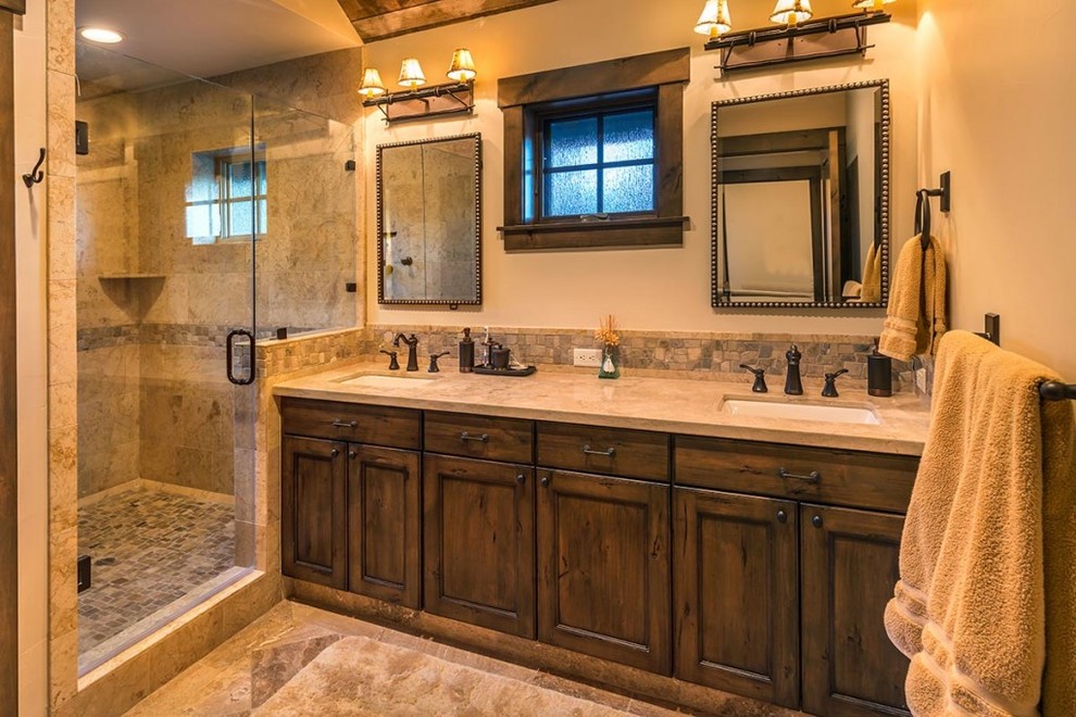 Medium sized rustic ensuite bathroom in Seattle with recessed-panel cabinets, dark wood cabinets, an alcove shower, beige tiles, stone tiles, beige walls, marble flooring, a submerged sink and granite worktops.