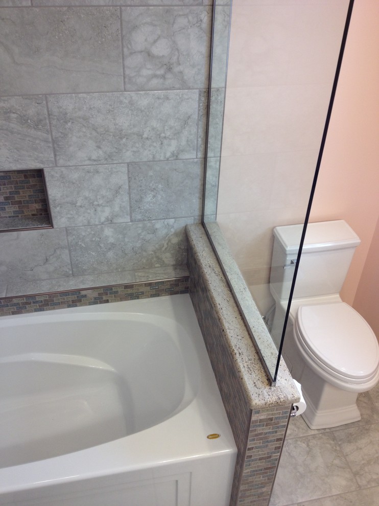 Inredning av ett klassiskt mellanstort badrum för barn, med ett undermonterad handfat, luckor med upphöjd panel, vita skåp, granitbänkskiva, ett badkar i en alkov, en dusch/badkar-kombination, grå kakel, porslinskakel, orange väggar och klinkergolv i porslin