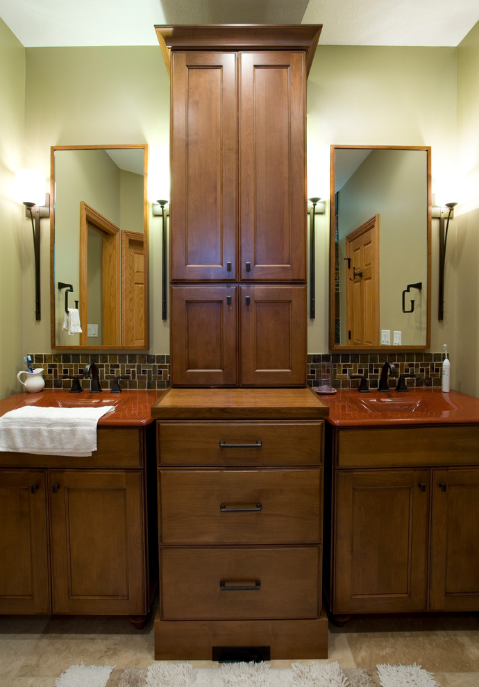 Réalisation d'une salle de bain principale tradition en bois brun de taille moyenne avec un placard avec porte à panneau encastré, un mur vert et un plan de toilette rouge.