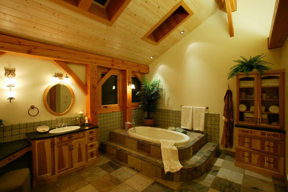 Inspiration för ett stort rustikt en-suite badrum, med ett nedsänkt handfat, luckor med infälld panel, skåp i mellenmörkt trä, bänkskiva i betong, ett hörnbadkar, grön kakel, stenkakel, beige väggar och skiffergolv