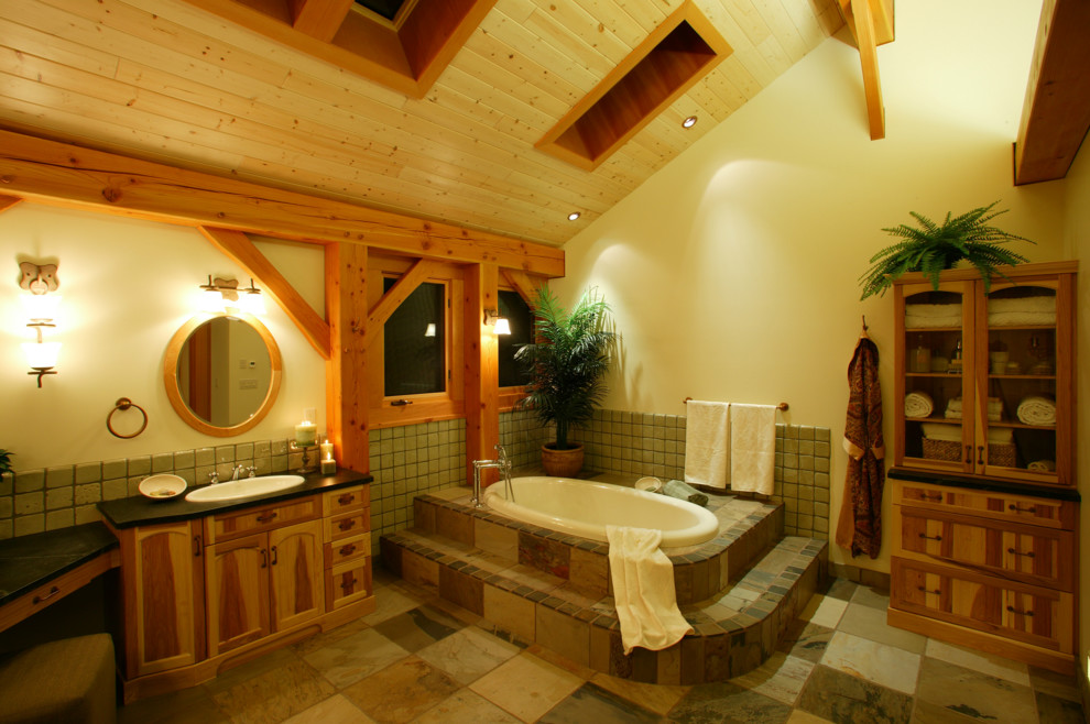 Idee per un'ampia stanza da bagno padronale country con consolle stile comò, ante in legno chiaro, piastrelle nere e lastra di pietra