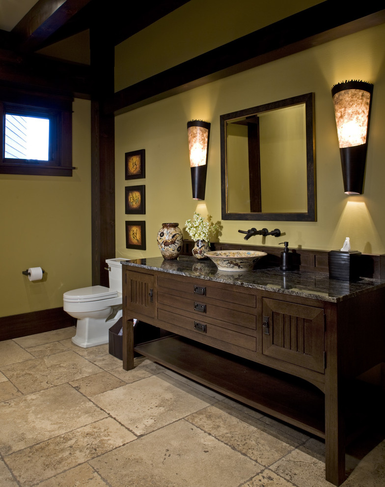 Bild på ett mellanstort amerikanskt en-suite badrum, med möbel-liknande, skåp i mörkt trä, en toalettstol med hel cisternkåpa, gula väggar, travertin golv och ett fristående handfat