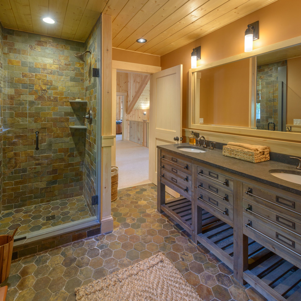 Inspiration for a mid-sized rustic 3/4 multicolored tile and stone tile brown floor doorless shower remodel in Boston with dark wood cabinets, brown walls, an undermount sink, a hinged shower door and flat-panel cabinets