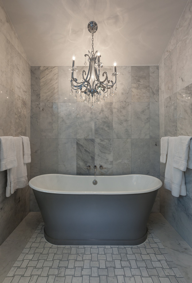Imagen de cuarto de baño tradicional grande con bañera exenta, baldosas y/o azulejos grises y suelo de mármol