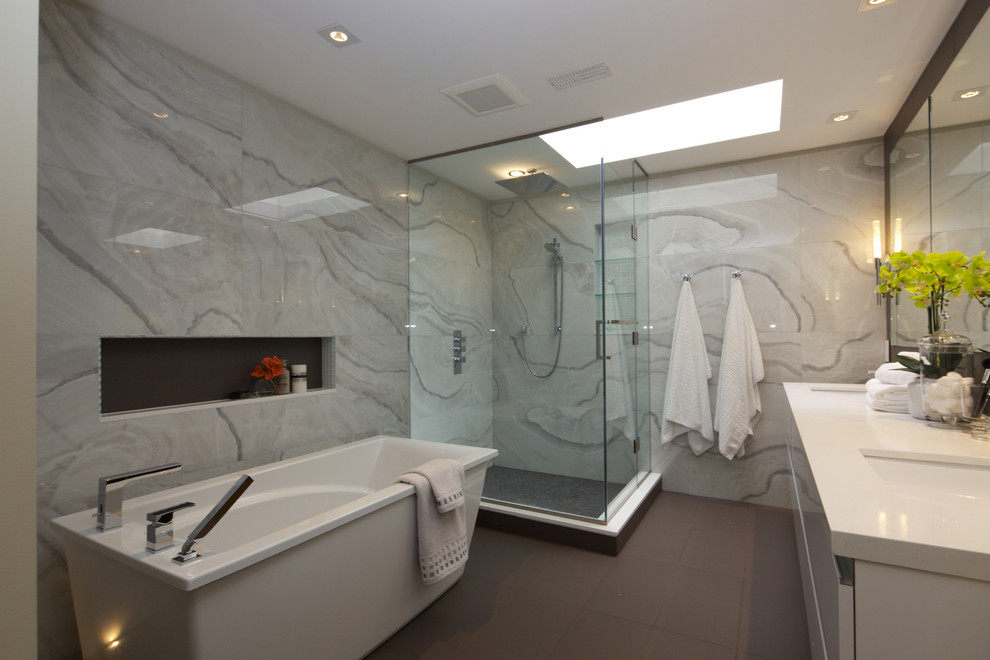 Modern inredning av ett stort en-suite badrum, med släta luckor, gula skåp, ett fristående badkar, en hörndusch, grå kakel, marmorkakel, grå väggar, ett undermonterad handfat, bänkskiva i akrylsten, grått golv och dusch med gångjärnsdörr