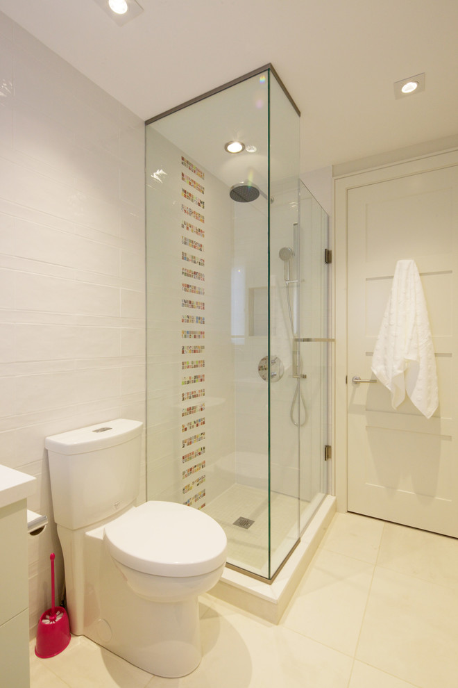 Photo of a medium sized modern shower room bathroom in Toronto with flat-panel cabinets, white cabinets, a corner shower, a two-piece toilet, white tiles, ceramic tiles, white walls, ceramic flooring, solid surface worktops, white floors and a hinged door.