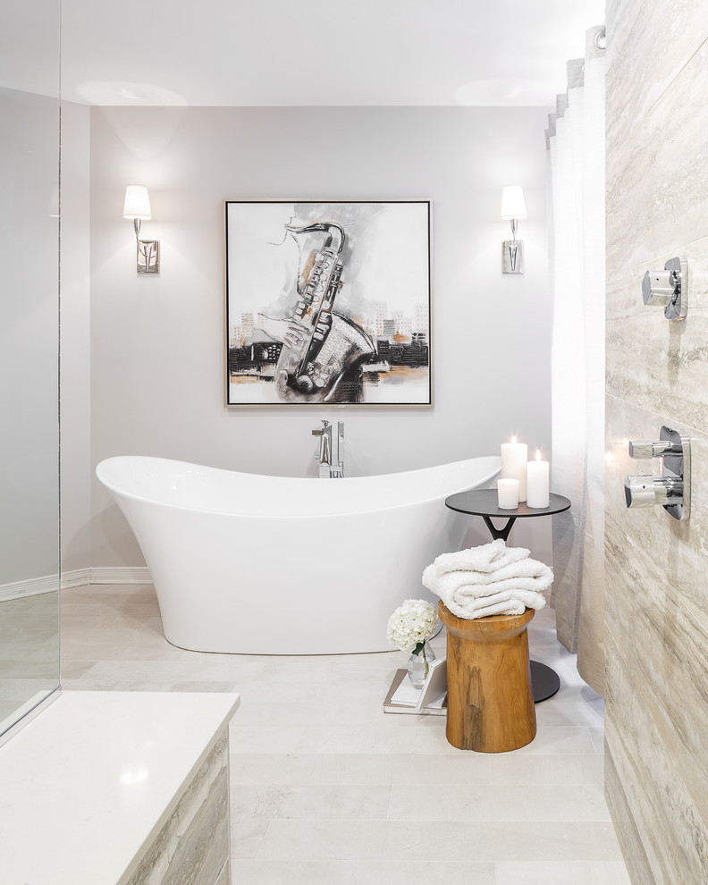 На фото: большая главная ванная комната в стиле неоклассика (современная классика) с белыми фасадами, отдельно стоящей ванной, серой плиткой и серыми стенами с