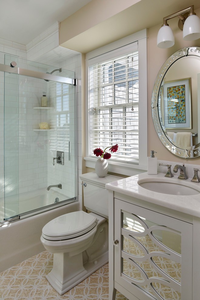 Inspiration för klassiska badrum, med ett undermonterad handfat, vita skåp, en dusch/badkar-kombination, en toalettstol med separat cisternkåpa, vit kakel, tunnelbanekakel, beige väggar, mosaikgolv, marmorbänkskiva och luckor med infälld panel