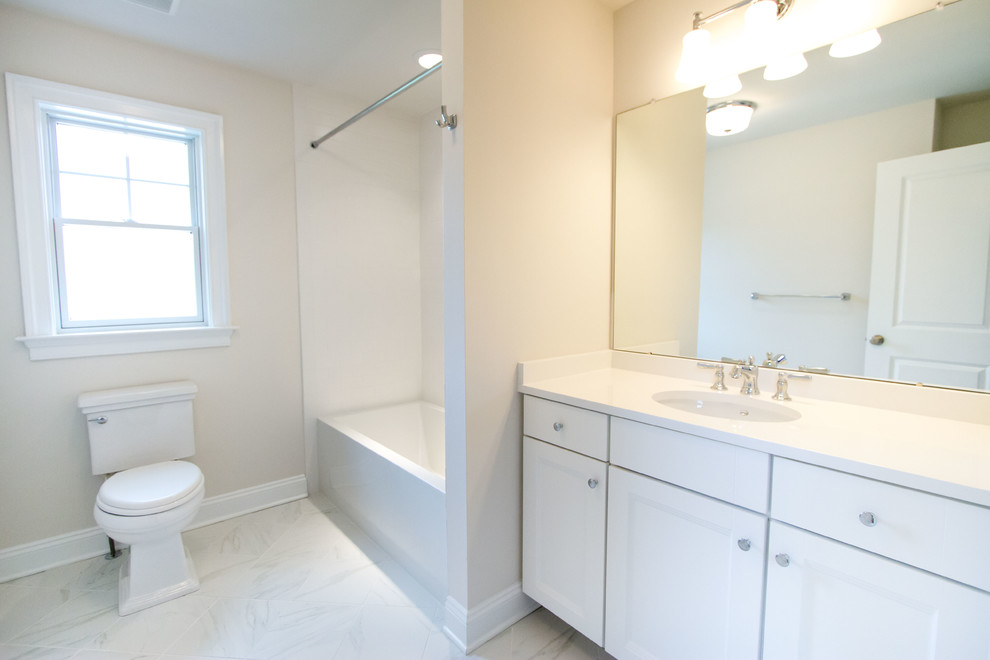Bild på ett mellanstort vintage en-suite badrum, med luckor med infälld panel, vita skåp, ett badkar i en alkov, en dusch/badkar-kombination, en toalettstol med separat cisternkåpa, beige väggar, klinkergolv i porslin och ett undermonterad handfat