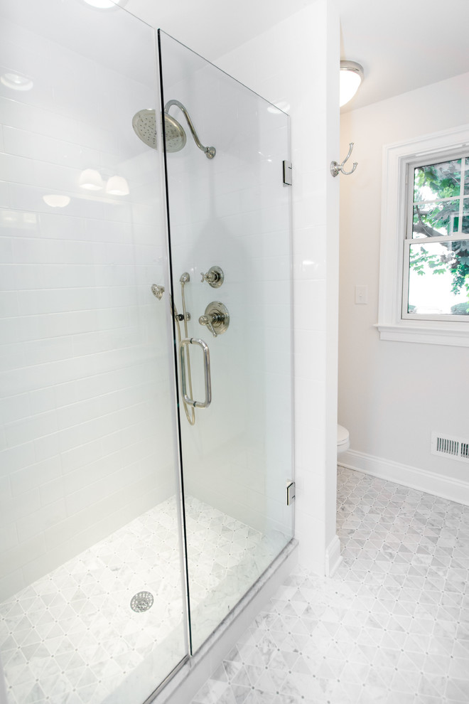 Cette image montre une grande douche en alcôve principale traditionnelle avec un placard à porte shaker, des portes de placard blanches, WC à poser, un mur blanc, un lavabo encastré et un plan de toilette en marbre.