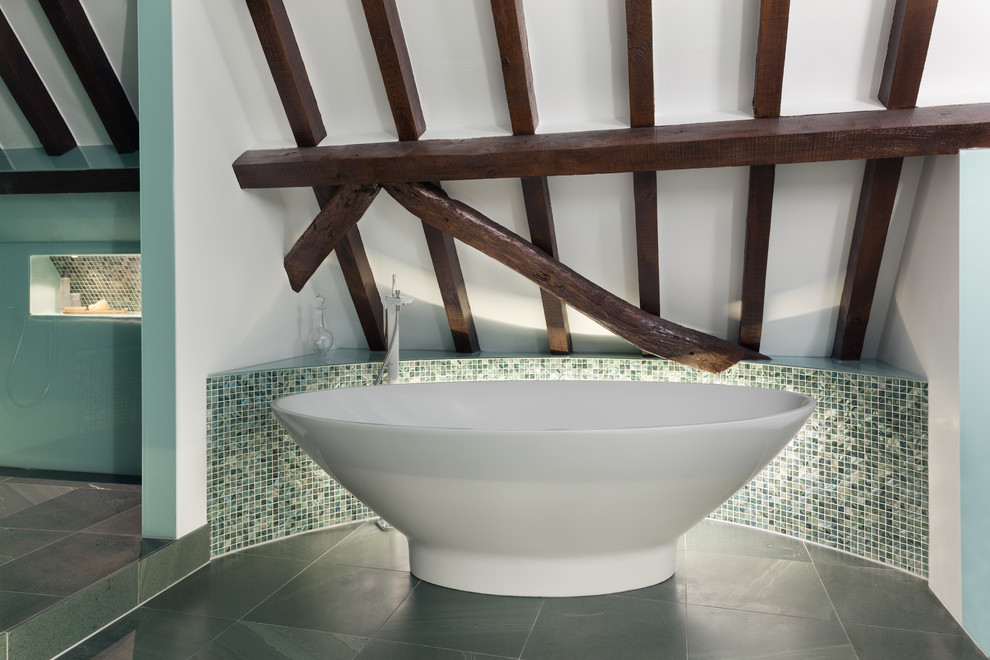 Badezimmer in Dachschräge mit freistehender Badewanne, Schieferboden und blauer Wandfarbe in London
