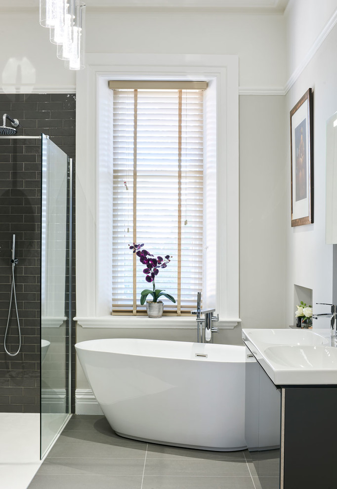 Стильный дизайн: детская ванная комната среднего размера в стиле модернизм с стеклянными фасадами, серыми фасадами, отдельно стоящей ванной, открытым душем, инсталляцией, серой плиткой и открытым душем - последний тренд