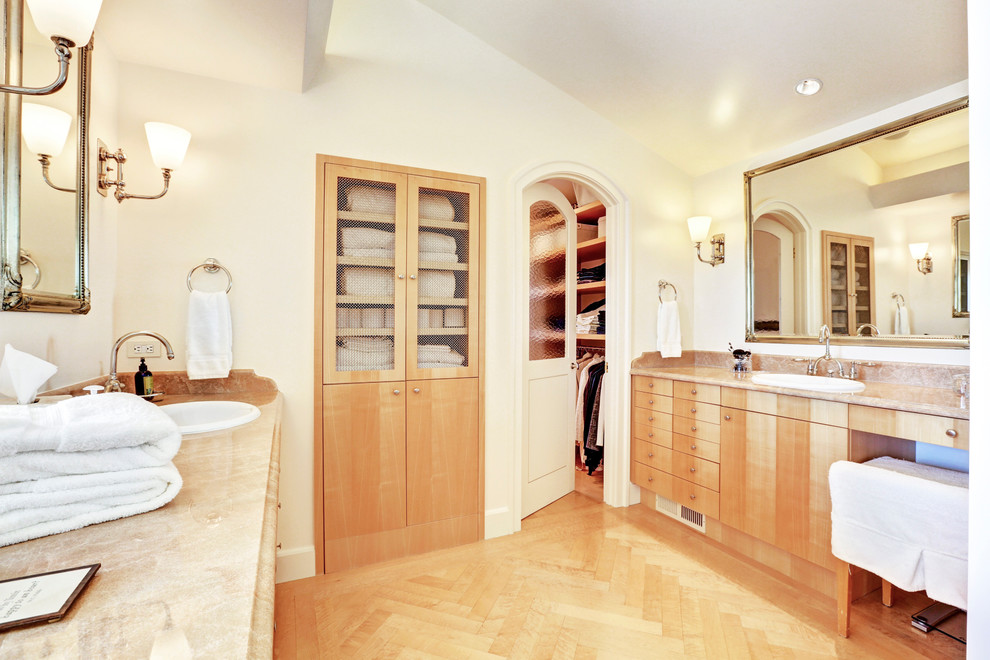 Foto de cuarto de baño principal tradicional de tamaño medio con lavabo encastrado, armarios con paneles lisos, puertas de armario de madera clara, paredes blancas, suelo de madera clara y vestidor