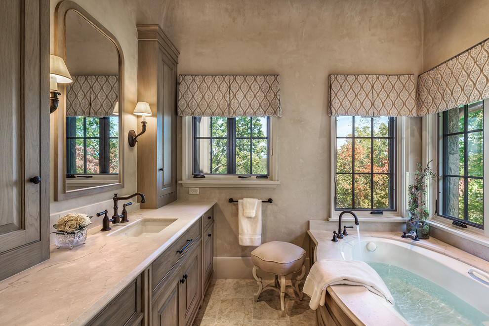 Пример оригинального дизайна: ванная комната в классическом стиле с фасадами с выступающей филенкой, темными деревянными фасадами, полновстраиваемой ванной, бежевыми стенами и врезной раковиной