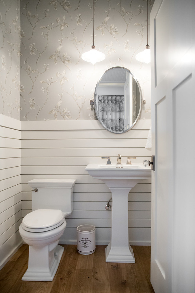 Mittelgroßes Klassisches Badezimmer mit Wandtoilette mit Spülkasten, braunem Holzboden und Sockelwaschbecken in Calgary