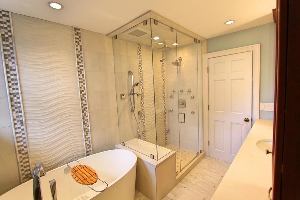 Источник вдохновения для домашнего уюта: главная ванная комната среднего размера в стиле неоклассика (современная классика) с фасадами с утопленной филенкой, коричневыми фасадами, отдельно стоящей ванной, угловым душем, унитазом-моноблоком, бежевой плиткой, керамогранитной плиткой, синими стенами, полом из керамогранита, врезной раковиной, столешницей из искусственного кварца, бежевым полом и душем с распашными дверями