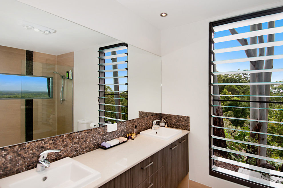 На фото: ванная комната в современном стиле с фасадами островного типа, светлыми деревянными фасадами, столешницей из искусственного кварца, открытым душем, керамогранитной плиткой и полом из керамогранита с