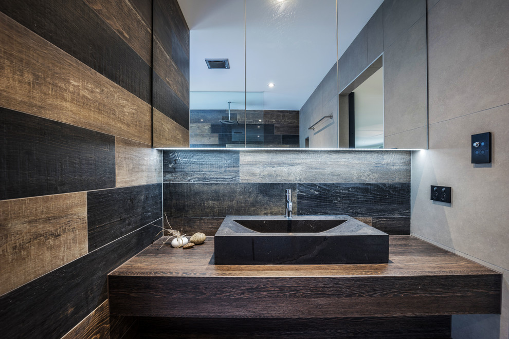 Large contemporary bathroom in Sunshine Coast with freestanding cabinets, dark wood cabinets, a walk-in shower, a one-piece toilet, brown tiles, porcelain tiles, brown walls, porcelain flooring, a vessel sink and laminate worktops.