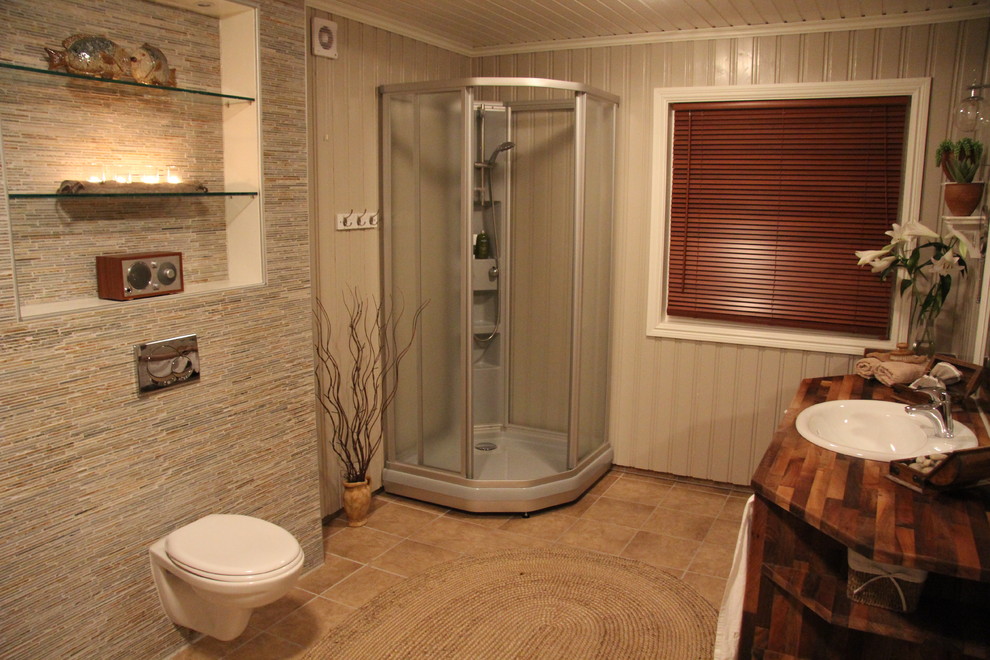 Inspiration pour une salle de bain méditerranéenne avec une douche d'angle, WC suspendus et un mur en pierre.