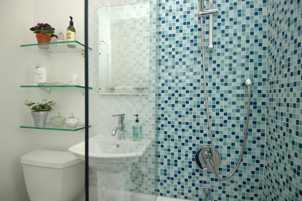 На фото: маленькая ванная комната в современном стиле с раковиной с пьедесталом, ванной в нише, душем над ванной, раздельным унитазом, синей плиткой, стеклянной плиткой, белыми стенами, полом из керамической плитки и душевой кабиной для на участке и в саду