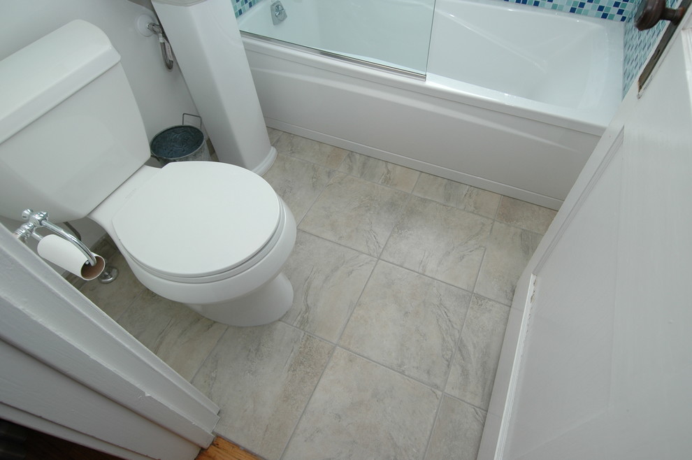 Foto på ett litet funkis badrum med dusch, med ett badkar i en alkov, en dusch/badkar-kombination, en toalettstol med separat cisternkåpa, blå kakel, glaskakel, vita väggar och klinkergolv i keramik
