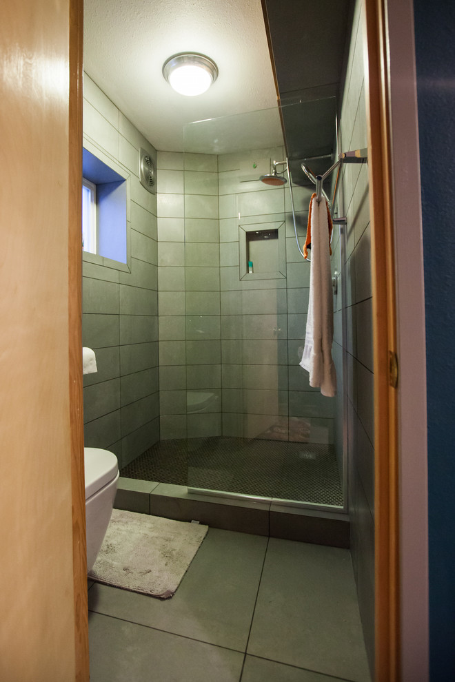 Aménagement d'une petite salle d'eau moderne avec une douche ouverte, WC suspendus, un carrelage gris, des carreaux de porcelaine, un mur orange et un sol en carrelage de porcelaine.