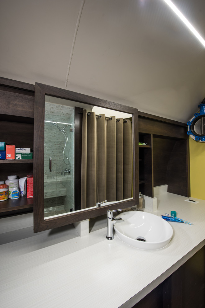 Diseño de cuarto de baño principal minimalista pequeño con lavabo sobreencimera, armarios con paneles lisos, puertas de armario de madera en tonos medios, encimera de laminado, sanitario de una pieza, baldosas y/o azulejos blancos, baldosas y/o azulejos de vidrio y paredes amarillas