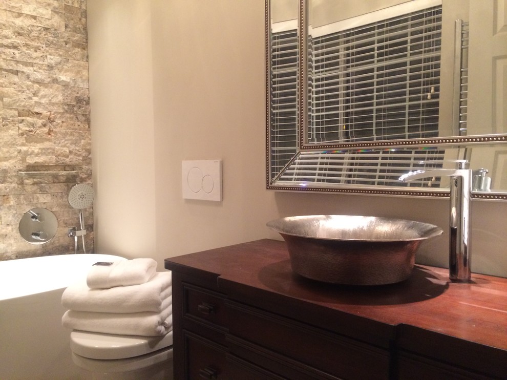 Inspiration för små amerikanska en-suite badrum, med möbel-liknande, skåp i mellenmörkt trä, träbänkskiva, grå kakel, stenkakel, ett fristående badkar, en öppen dusch, en vägghängd toalettstol, ett fristående handfat, grå väggar och klinkergolv i porslin