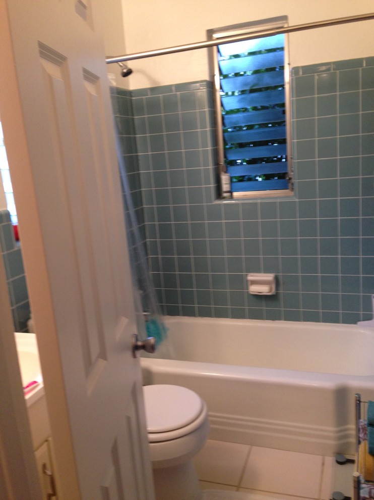 Aménagement d'une salle de bain rétro avec un carrelage bleu et des carreaux de porcelaine.