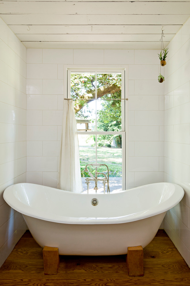 ポートランドにあるカントリー風のおしゃれなお風呂の窓 (置き型浴槽) の写真