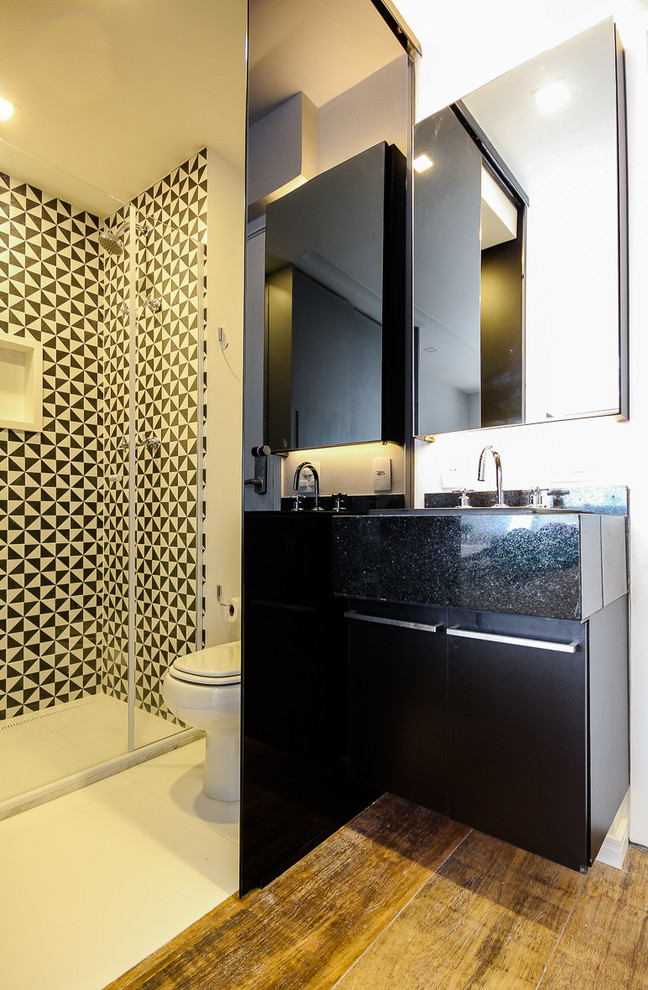 Kleines Modernes Duschbad mit schwarzen Schränken, schwarz-weißen Fliesen, Keramikfliesen, weißer Wandfarbe, Keramikboden, Granit-Waschbecken/Waschtisch, weißem Boden und Falttür-Duschabtrennung in Sonstige