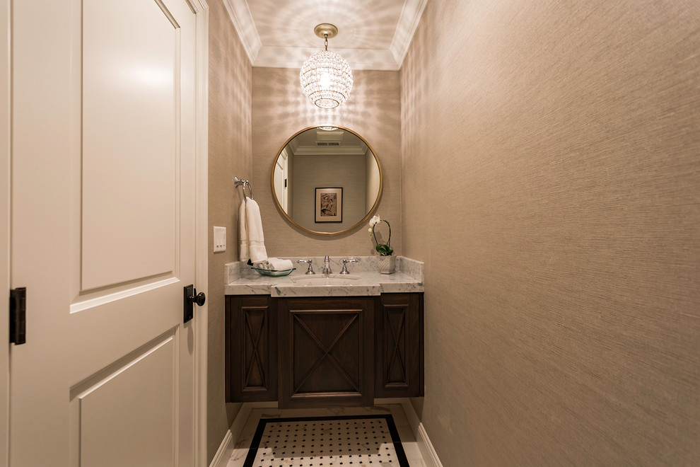 Klassisk inredning av ett badrum, med skåp i mörkt trä, beige väggar och ett undermonterad handfat