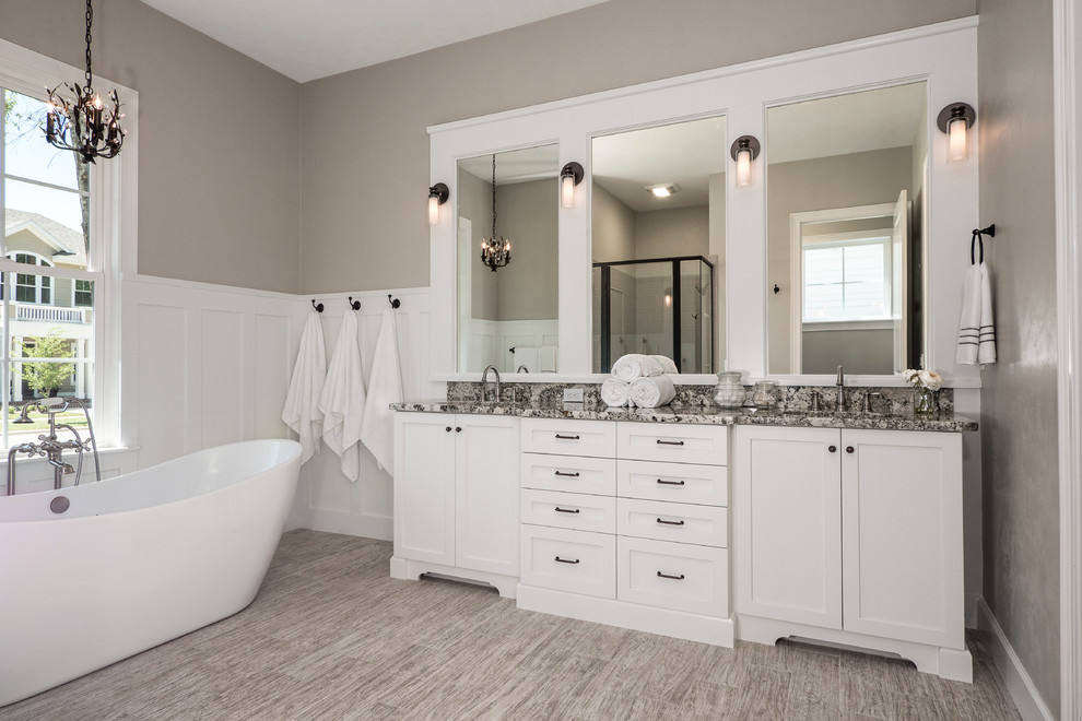 Design ideas for a large traditional ensuite bathroom in Miami with a submerged sink, shaker cabinets, white cabinets, granite worktops, a freestanding bath, grey walls, ceramic flooring and grey floors.