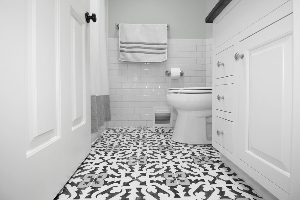 Cette image montre une petite salle de bain principale traditionnelle avec un placard à porte shaker, des portes de placard blanches, une baignoire en alcôve, un combiné douche/baignoire, WC séparés, un carrelage blanc, des carreaux de céramique, un mur vert, un sol en carrelage de céramique, un lavabo encastré, un plan de toilette en quartz modifié, un sol multicolore, une cabine de douche avec un rideau et un plan de toilette gris.