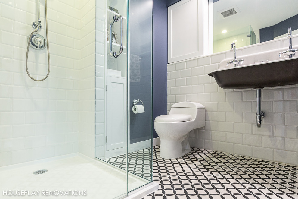 Bild på ett mellanstort funkis en-suite badrum, med ett väggmonterat handfat, en hörndusch, en toalettstol med hel cisternkåpa, vit kakel, tunnelbanekakel och mosaikgolv