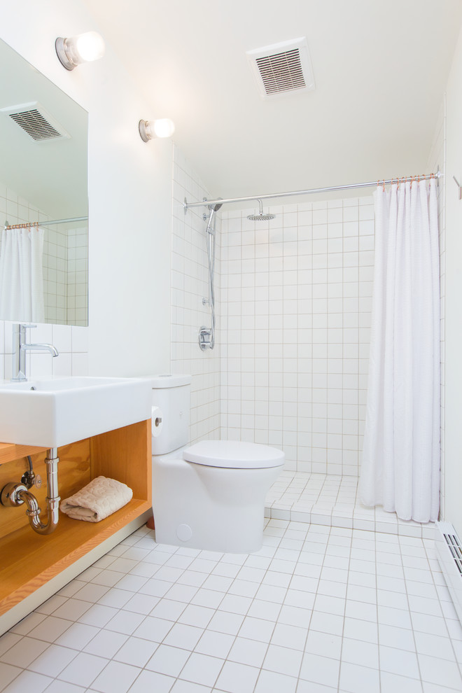 Idéer för ett mellanstort modernt brun badrum med dusch, med öppna hyllor, skåp i mellenmörkt trä, en dusch i en alkov, en toalettstol med separat cisternkåpa, vit kakel, vita väggar, ett väggmonterat handfat, vitt golv, dusch med duschdraperi, keramikplattor, klinkergolv i keramik och träbänkskiva