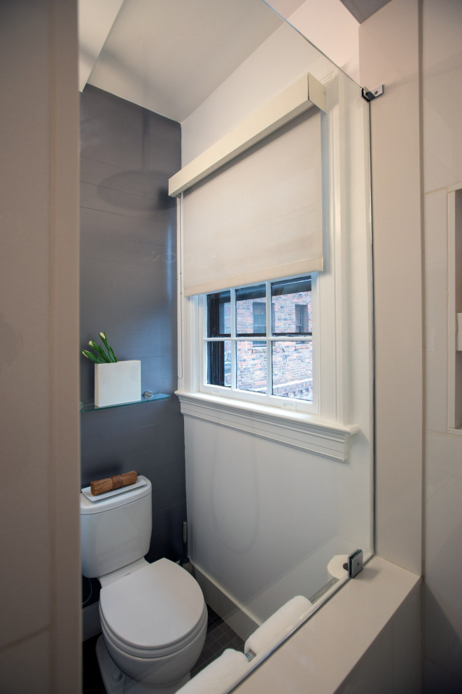 Свежая идея для дизайна: маленькая ванная комната в стиле модернизм с плоскими фасадами, белыми фасадами, угловым душем, раздельным унитазом, белой плиткой, керамогранитной плиткой, серыми стенами, полом из керамической плитки, душевой кабиной, подвесной раковиной, столешницей из искусственного камня, серым полом, открытым душем, белой столешницей, сиденьем для душа, тумбой под одну раковину, подвесной тумбой, многоуровневым потолком и панелями на стенах для на участке и в саду - отличное фото интерьера