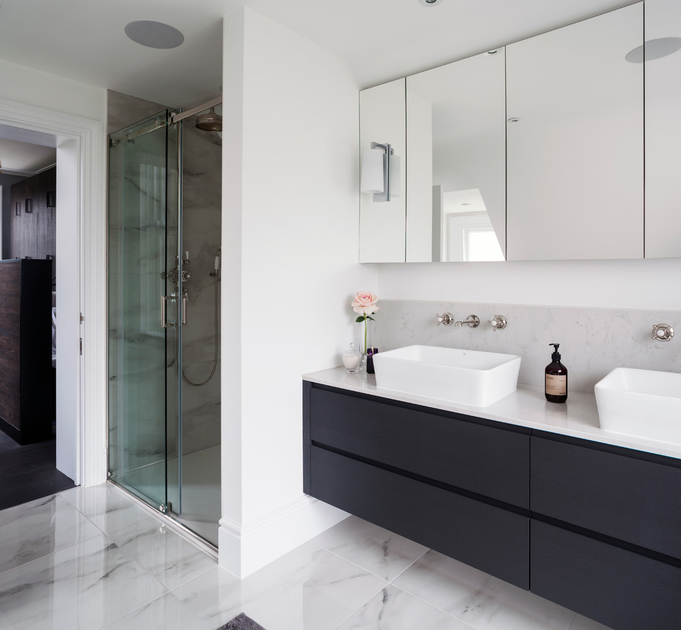 Modelo de cuarto de baño contemporáneo con armarios con paneles lisos, puertas de armario azules, paredes blancas, suelo de mármol, lavabo suspendido, encimera de mármol y suelo gris