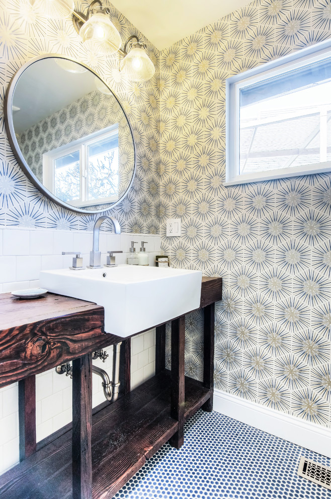 Пример оригинального дизайна: ванная комната среднего размера в современном стиле с открытыми фасадами, душем над ванной, белой плиткой, керамогранитной плиткой, разноцветными стенами, полом из мозаичной плитки, столешницей из дерева, синим полом, душем с распашными дверями, темными деревянными фасадами, душевой кабиной, накладной раковиной и унитазом-моноблоком