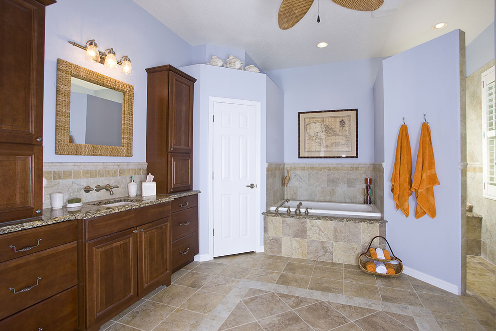 Ejemplo de cuarto de baño tradicional con armarios con paneles con relieve y bañera encastrada