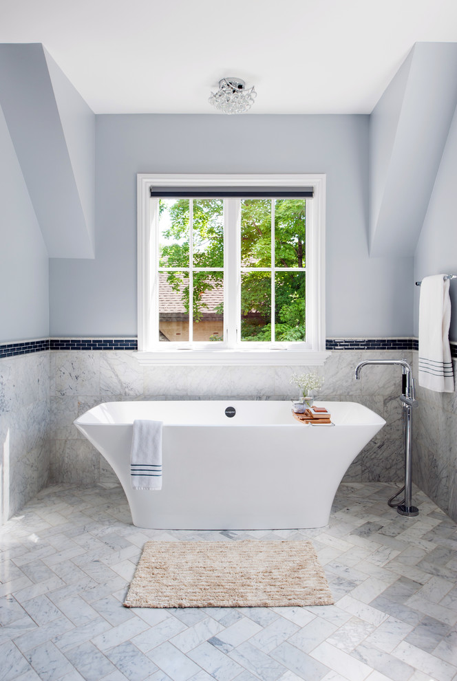 Immagine di una grande stanza da bagno padronale moderna con vasca freestanding, piastrelle grigie, piastrelle in pietra, pavimento in marmo, pareti blu e pavimento grigio