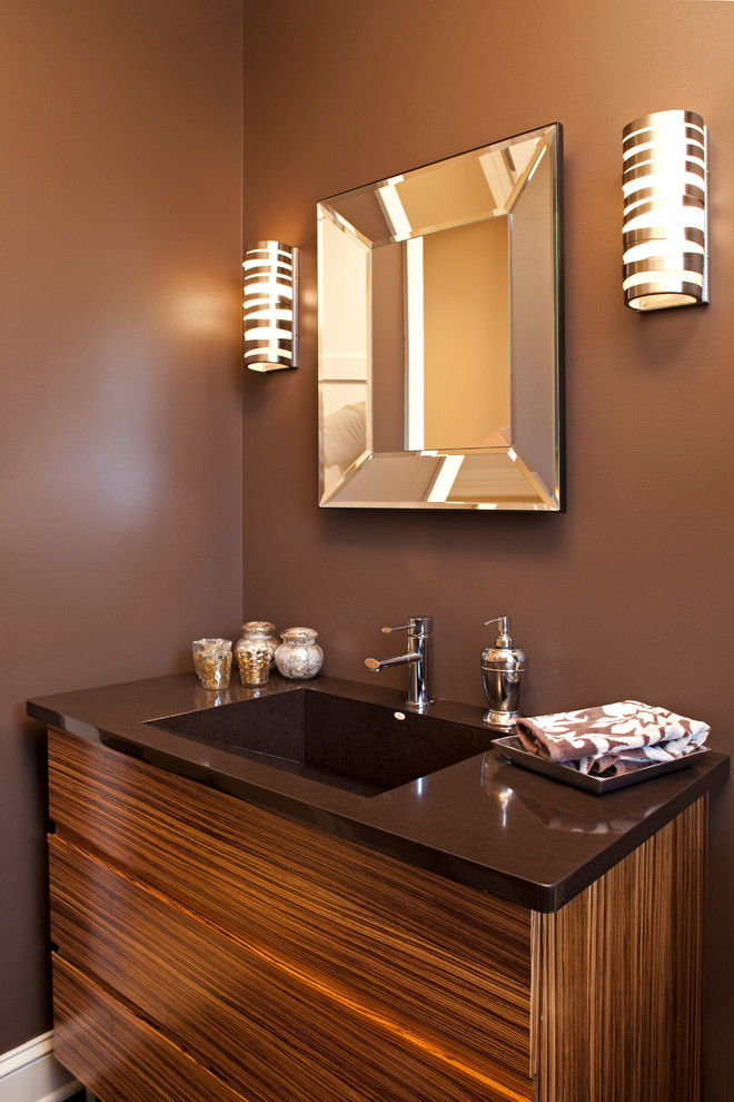 Aménagement d'une salle de bain contemporaine avec un lavabo intégré, un placard à porte plane, un mur marron et un plan de toilette marron.